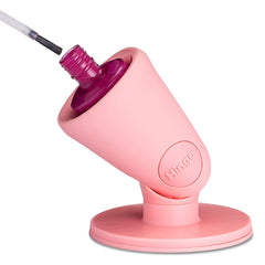 Tweexy Hinge maintient une bouteille de vernis anti-renversement sur une surface.