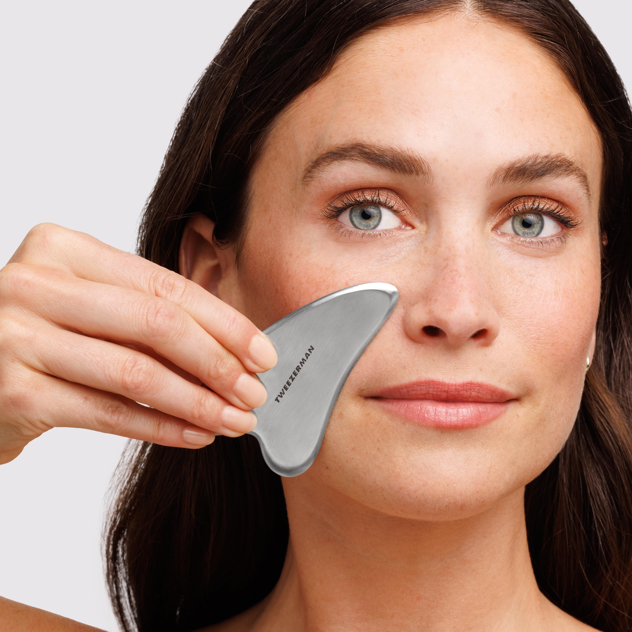 Contours du visage plus fermes grâce au Gua Sha Tweezerman en acier inoxydable.