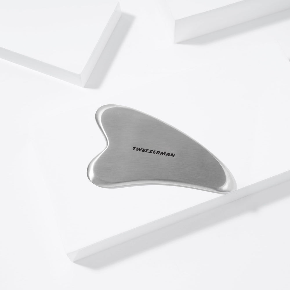 Relaxation musculaire du visage avec le Gua Sha Tweezerman en acier inoxydable.