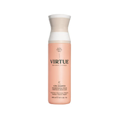 Shampoing VIRTUE Curl Jojoba sur boucles crèmeuses, hydratation naturelle.