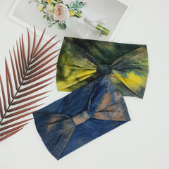 Bandeau Yonuf boho bleu tie-dye en position sportive pour yoga et entraînements.